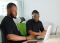Young African professionals using digital financial tools on laptops
