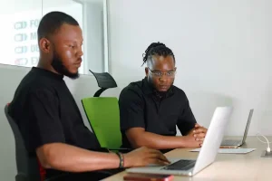 Young African professionals using digital financial tools on laptops