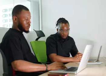 Young African professionals using digital financial tools on laptops