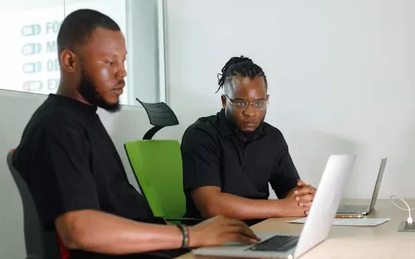 Young African professionals using digital financial tools on laptops