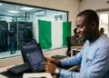 A Nigerian professional using an AI chatbot on a smartphone with the Nigerian flag and a data centre in the background